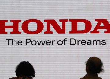 Dos personas miran el eslogan de la marca de coches nipona Honda.