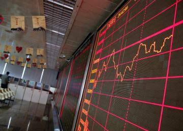 Un panel ofrece información bursátil en una agencia de corredores en Pekín (China).