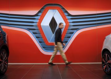 Una persona pasa por delante de la enseña de la marca Renault.