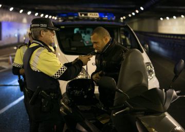 Un agente de la Guardia Urbana de Barcelona hace la prueba de alcoholemia a un motorista.