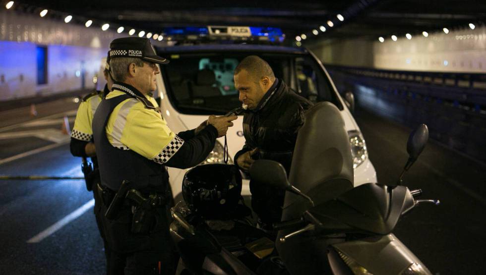 Un agente de la Guardia Urbana de Barcelona hace la prueba de alcoholemia a un motorista