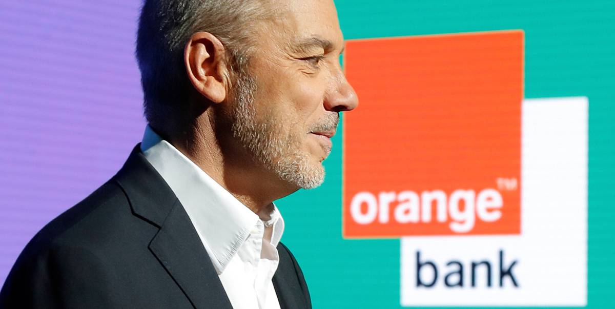 El presidente y consejero delegado de Orange, Stephane Richard, posa con un cartel de Orange Bank en el fondo.