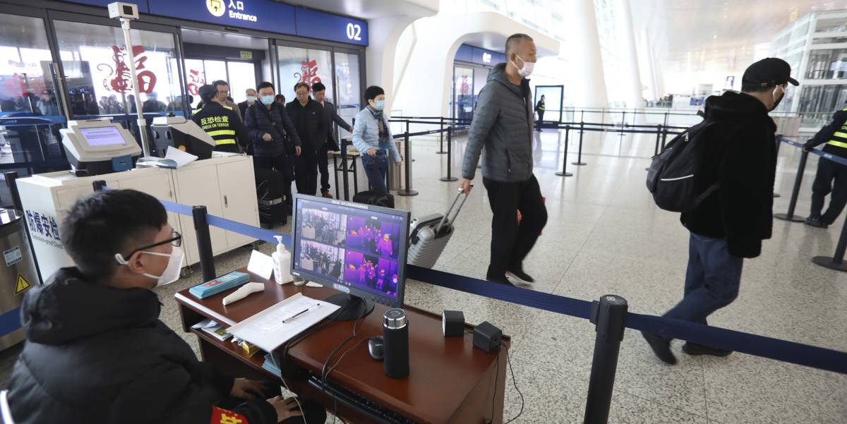 Un operario controla a través de una pantalla la temperatura corporal de los viajeros en el aeropuerto internacional de Wuhan.