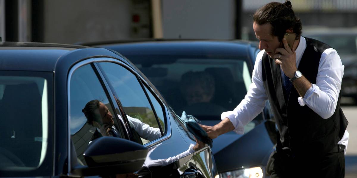 Un conductor de Cabify limpia uno de los coches de la plataforma.