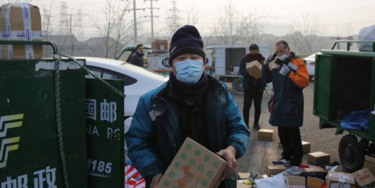 Empleados de una empresa de repartidores con máscara en Beijing (China).