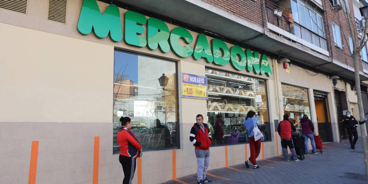 Varias personas esperan para poder entrar a comprar en un supermercado Mercadona de Madrid en plena crisis sanitaria por coronavirus.