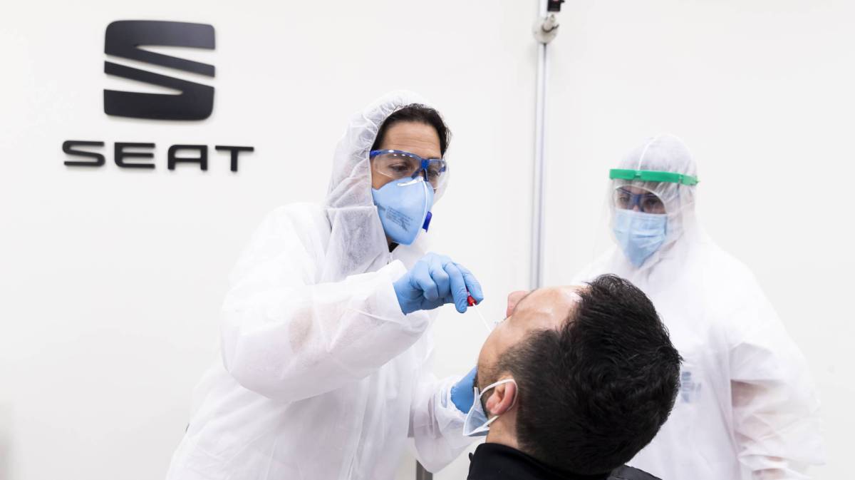Una empleada del servicio médico de Seat realiza un test PCR a un trabajador de la planta.
