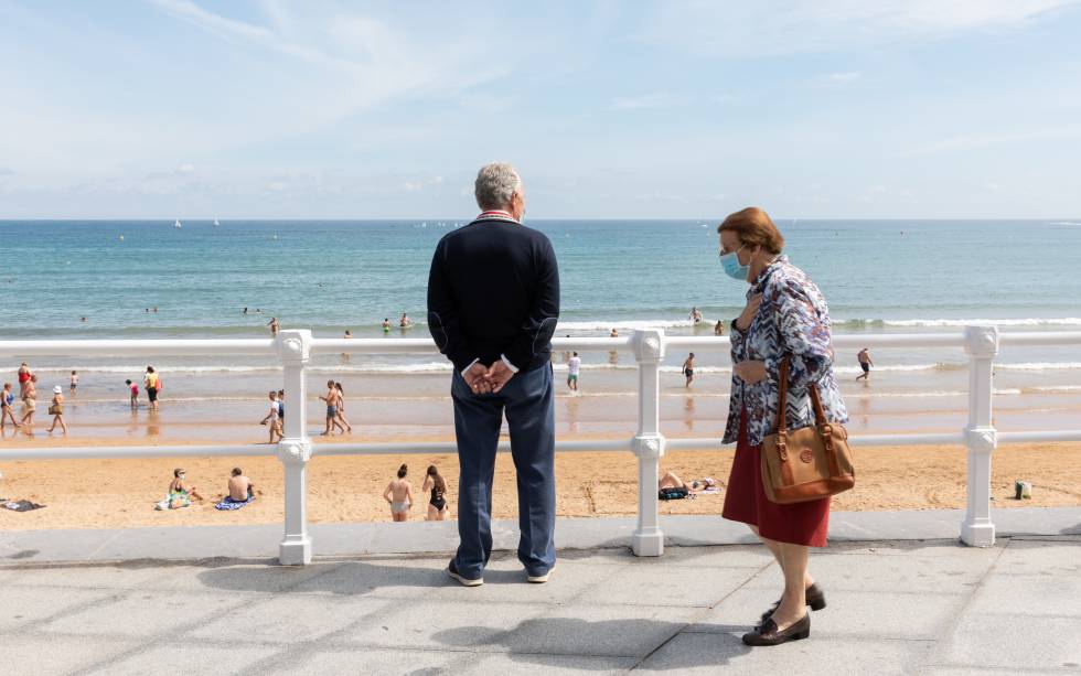 Dos personas utilizan una mascarilla en un paseo por Gijón (Asturias), el pasado verano.
