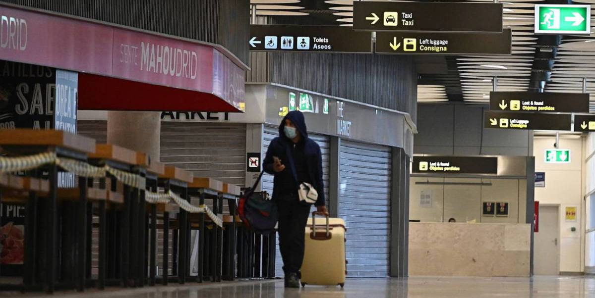 Un pasajero camina por el aeropuerto de Barajas entre tiendas y bares cerrados.
