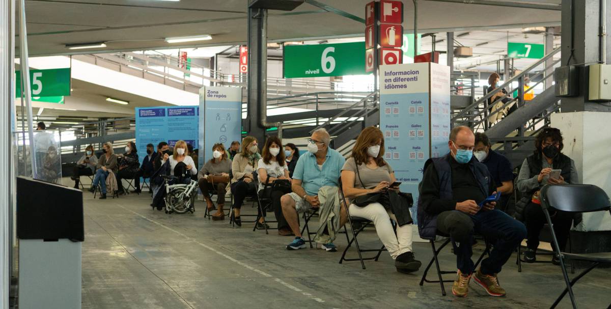 Decenas de personas entre 55 y 59 años hacen cola para vacunarse en el centro de vacunación de la Fira de Barcelona.