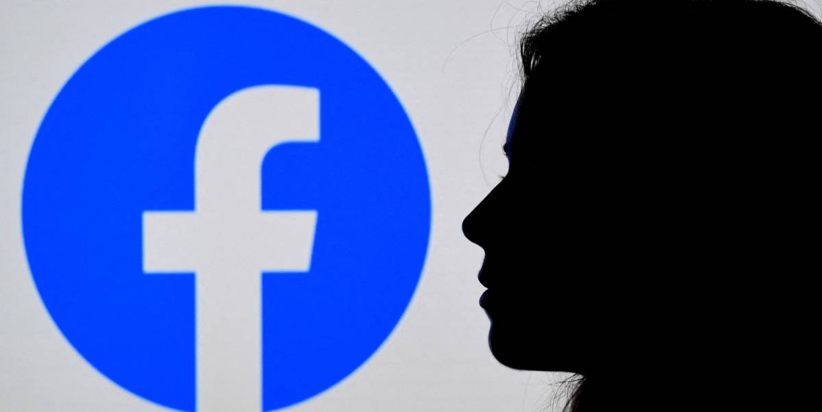 Una persona mira un logo de Facebook.