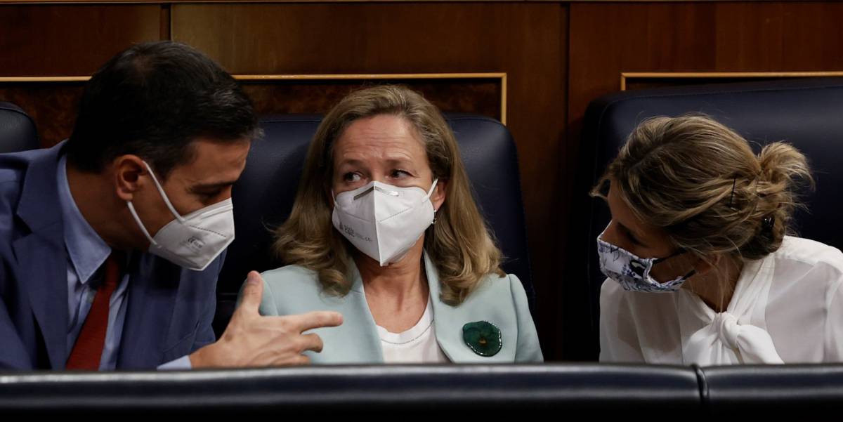 El presidente del Gobierno, Pedro Sánchez, conversa con la vicepresidenta segunda y ministra de Trabajo, Yolanda Díaz, (derecha) en presencia de la vicepresidenta primera y ministra de Asuntos Económicos, Nadia Calviño.