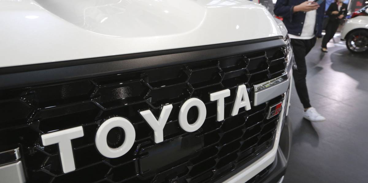 Una persona camina junto a un vehículo de Toyota en Tokyo.