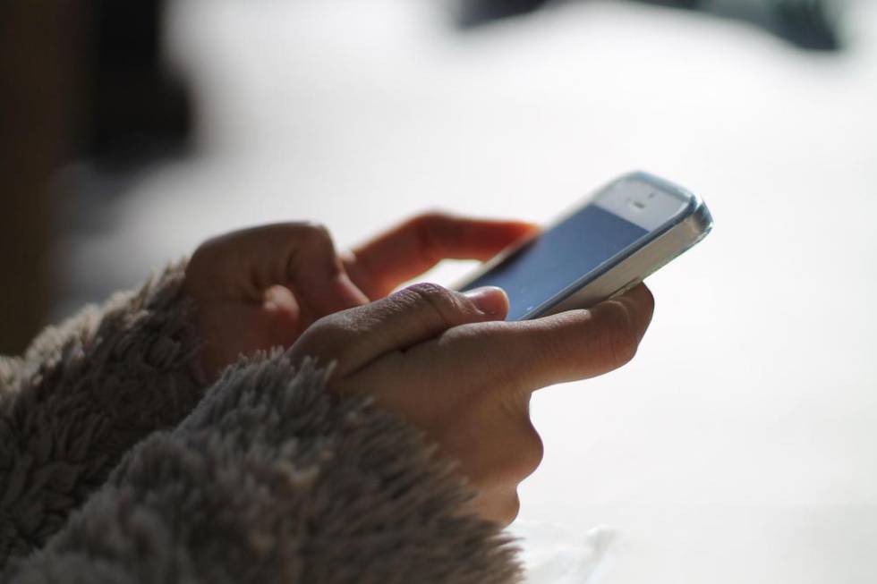 Chica utilizando WhatsApp con un iPhone