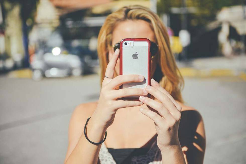Chica haciendo una foto con un iPhone