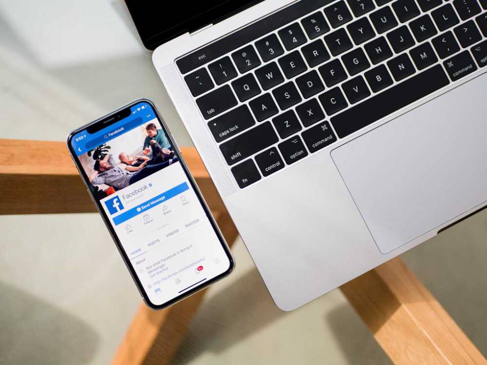Teléfono con Facebook con un portátil al lado