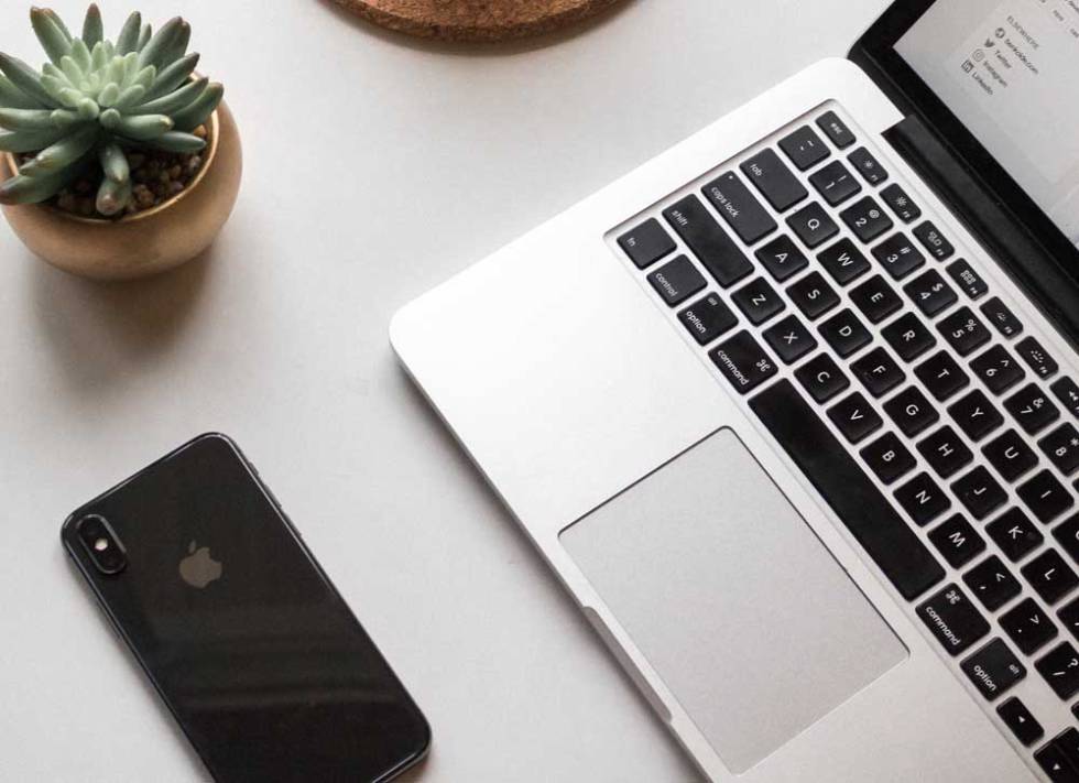 Telñefono iPhone al lado de un MacBook