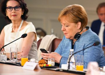La canciller alemana, Angela Merkel, consulta su móvil en un desayuno de trabajo del Consejo Asesor de Igualdad de Género en la cumbre del G7 celebrada el 8 de junio de 2018 en Quebec, Canada.