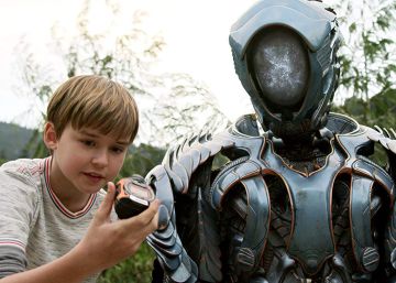 MaxwelL Jenkins como Will Robinson con inseparable robot en una escena del remake de 'Lost in Space' (2018)