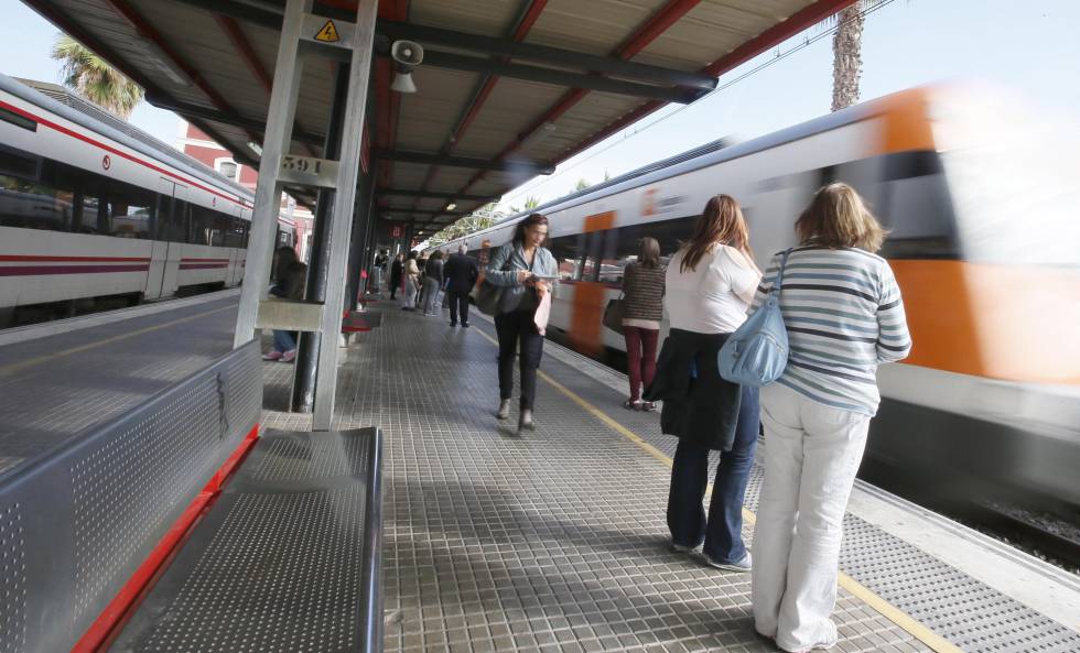 Un grupo de viajeros espera la parada de un tren en un andén de Cercanías de Renfe.