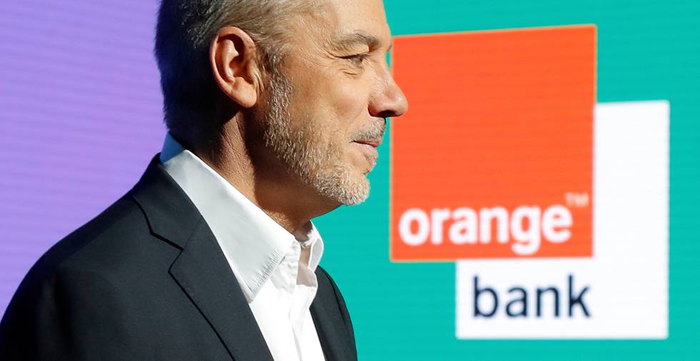 El presidente y consejero delegado de Orange, Stephane Richard, posa con un cartel de Orange Bank en el fondo.