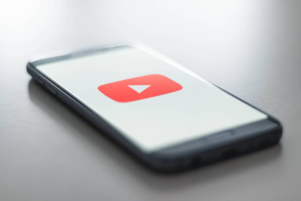 Logo de YouTube en un móvil con fondo blanco