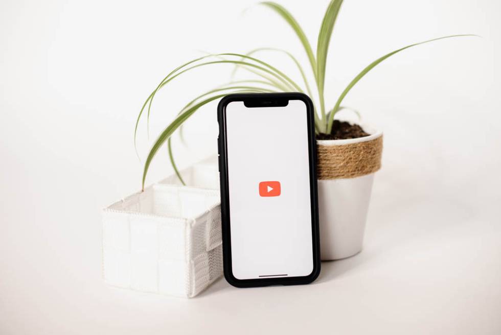 YouTube logo on a smartphone against a white background