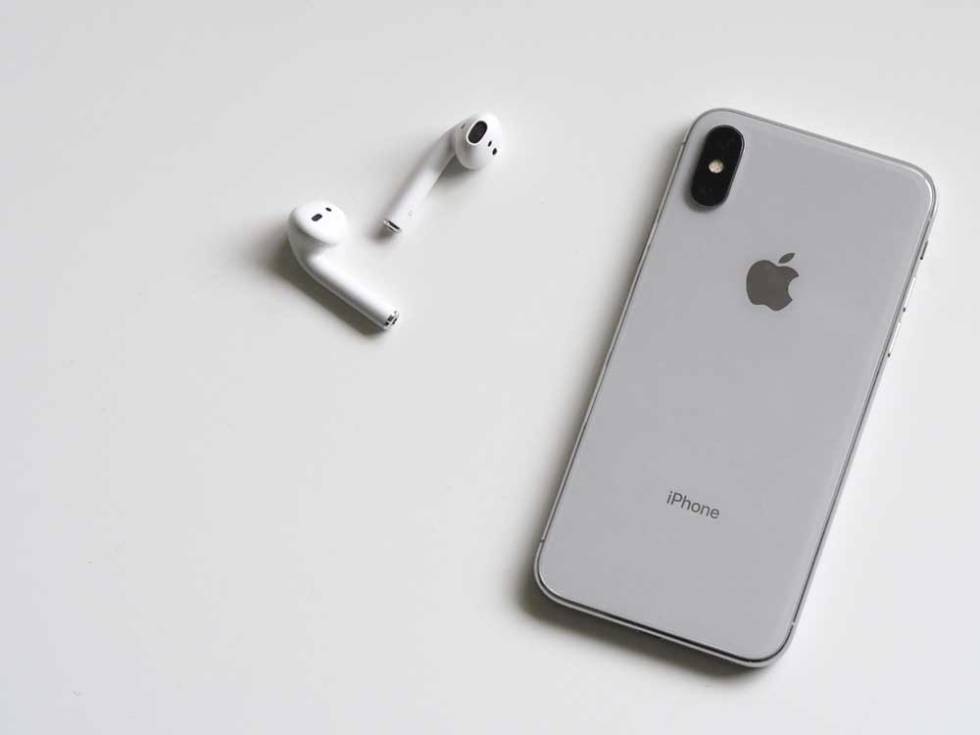 Apple AirPods headphones next to an iPhone