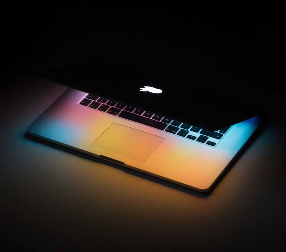 Apple MacBook computer with black background