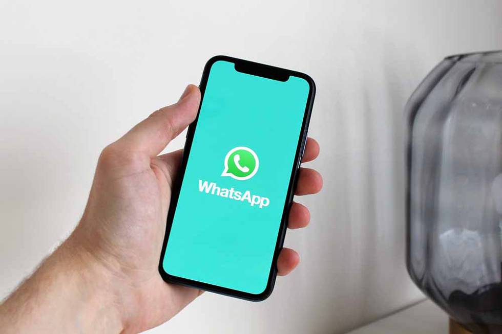 Logo de WhatsApp en un teléfono con fondo azul