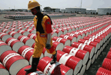 Un trabajador camina sobre barriles de petróleo en una refinería de Indonesia